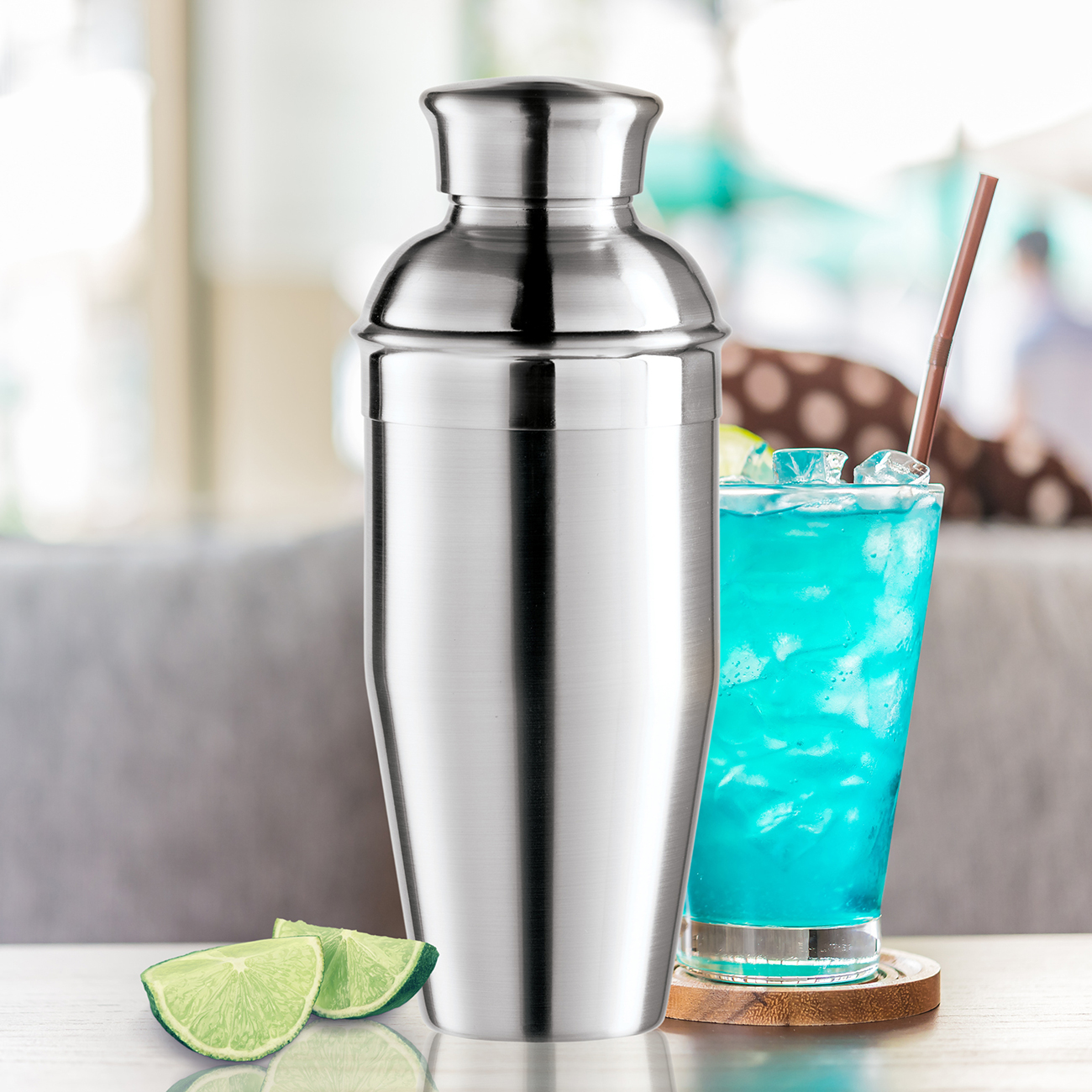 Lifestyle View of Oggi Cocktail Shaker Next To A Blue Drink