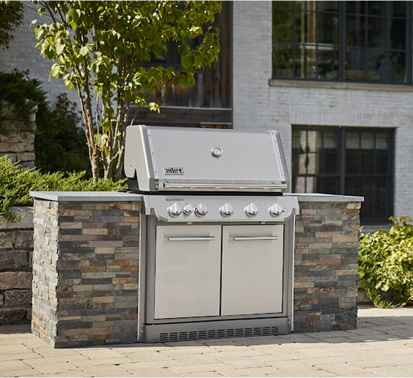 Glamour shot of a built-in weber summit stainless steel grill in a serene backyard setting