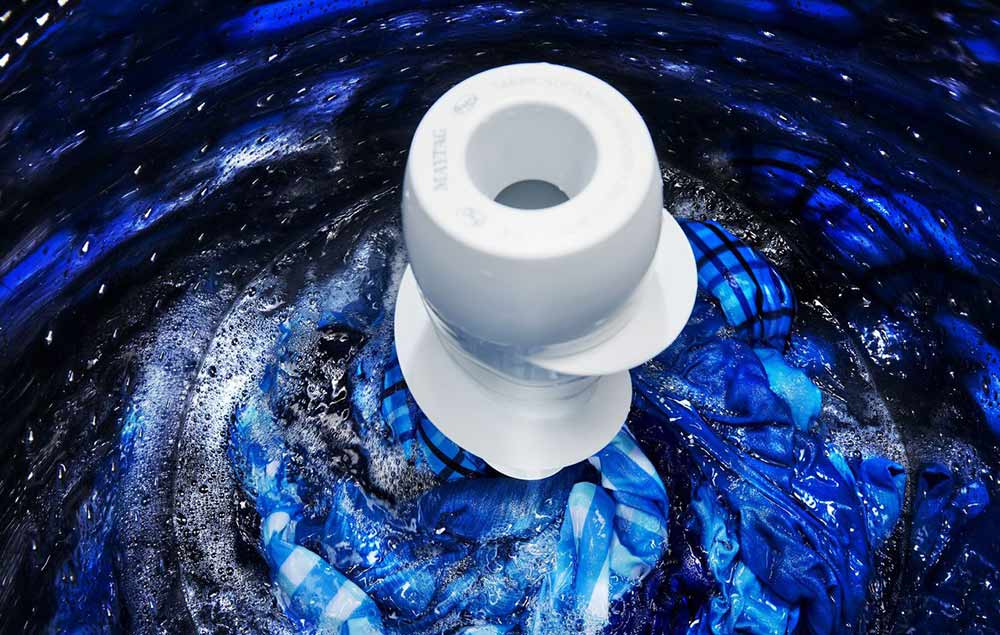 Open washer with fabrics around a wash agitator