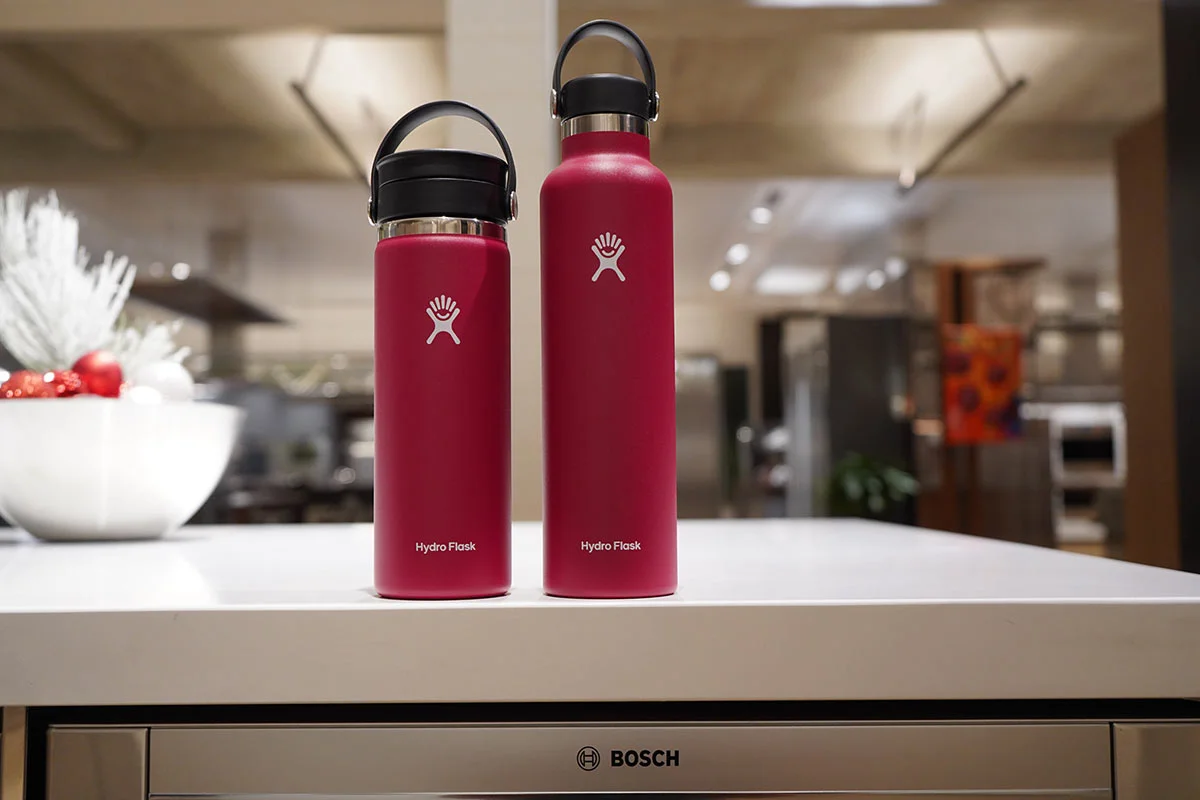 Two red Hydro Flask insulated tumblers sitting on top of a Bosch dishwasher