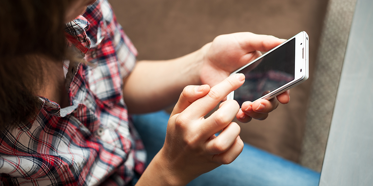 A girl holding a cell phone in front of her