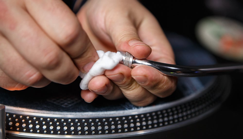 Person cleaning a record needle