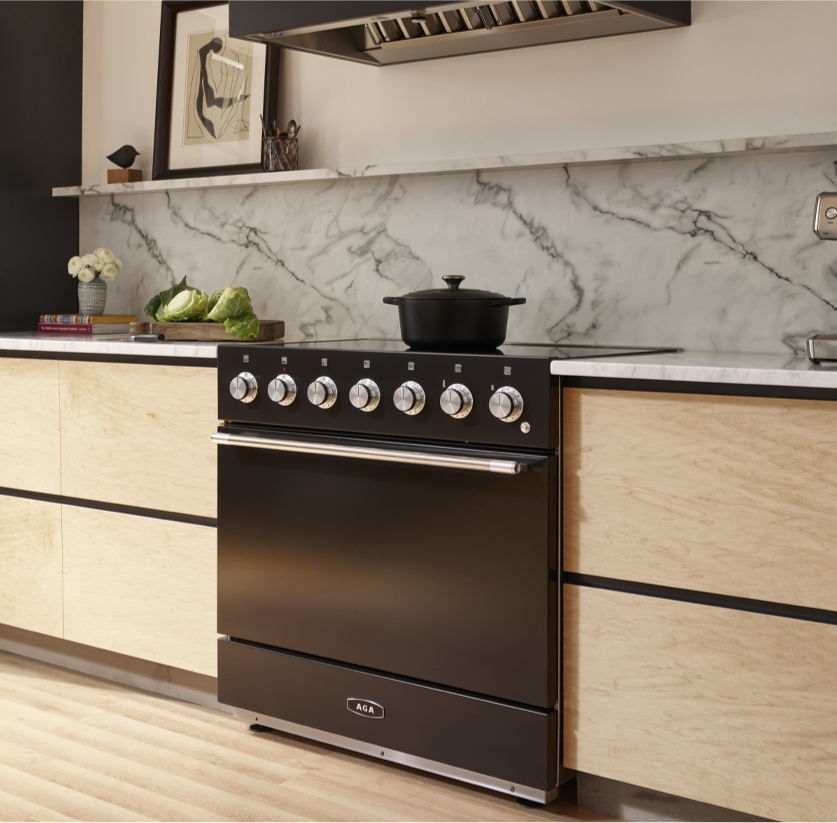Contemporary kitchen showcasing a black Aga Mercury Series Range, door ajar to reveal the food inside