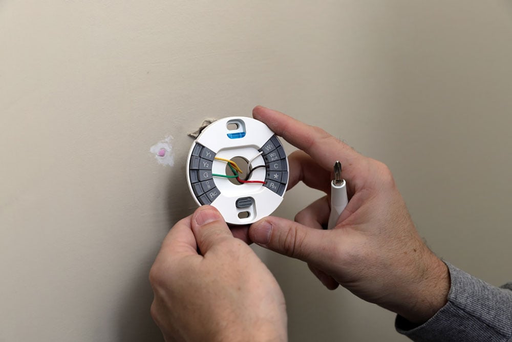 Person installing a thermostat