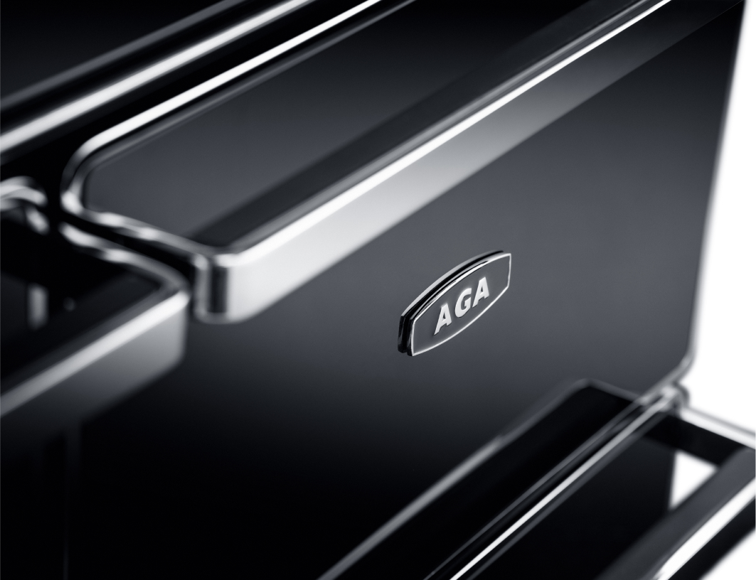 AGA range in a high-end kitchen with dark stone walls and built-in shelving