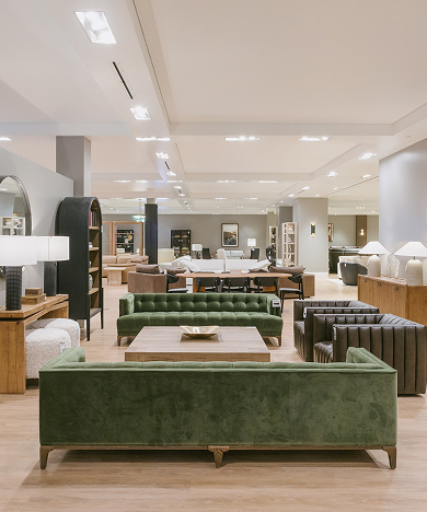 Modern furniture showroom with green seating and warm interior design.