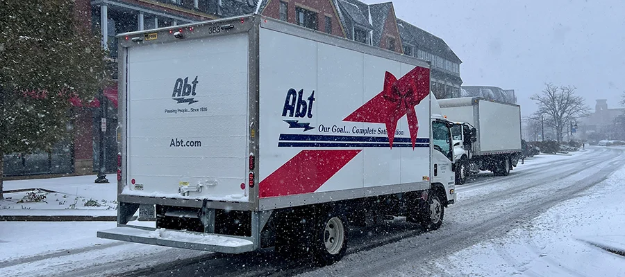 An Abt holiday delivery truck parked outside of our store while it's snowing