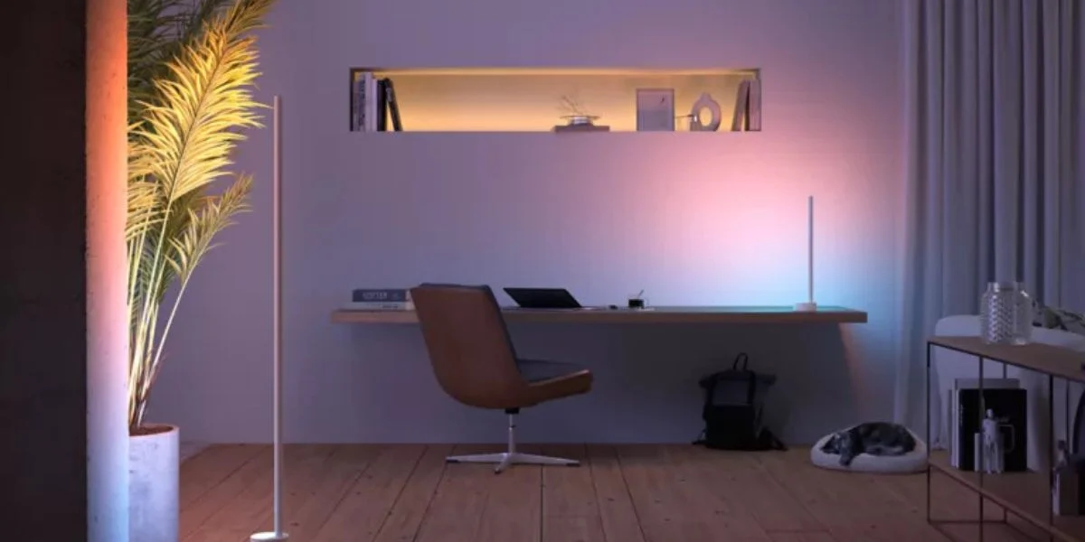 minimalist desk in a home office accented by muted colorful smart lights