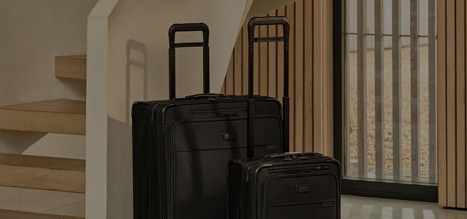 Close up shot of both a tumi carry-on luggage and a checked bag