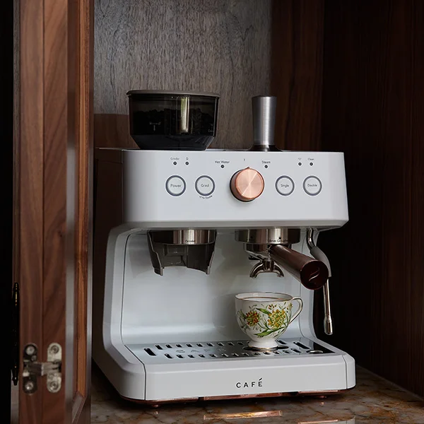 close-up of white Cafe espresso machine with a floral teacup on the cup rest