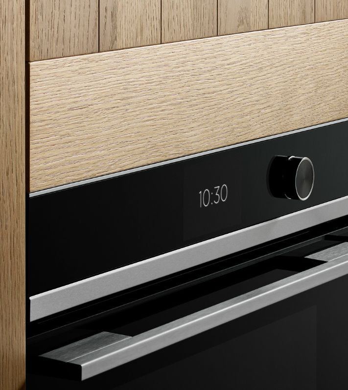 A stylish kitchen with wooden walls displaying a Gaggenau built-in wine refrigerator for optimal wine storage