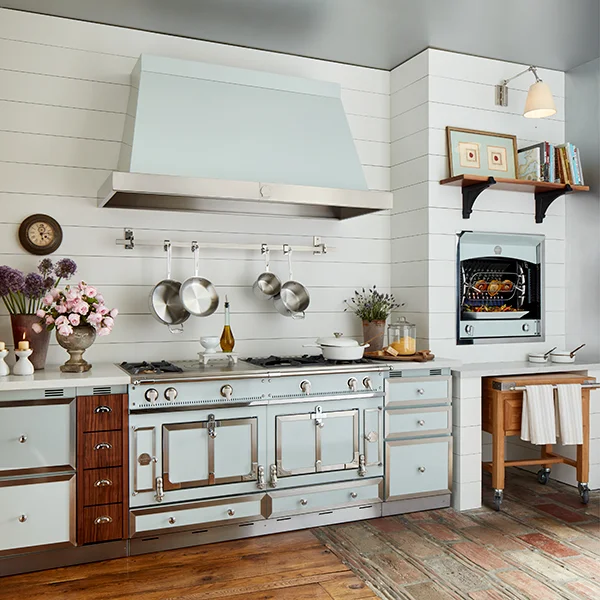 A kitchen with a light pastel blue range and range hood