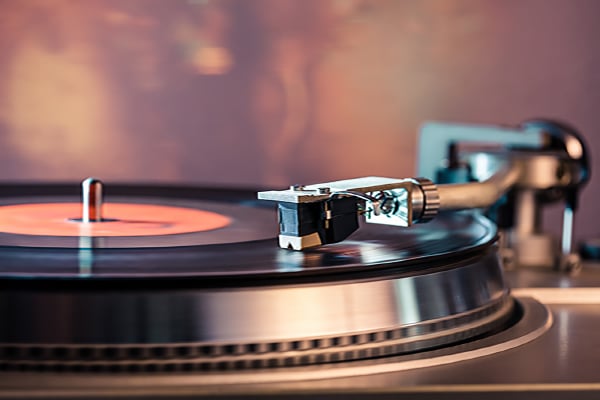 Turntable Playing Music beside a wireless speaker