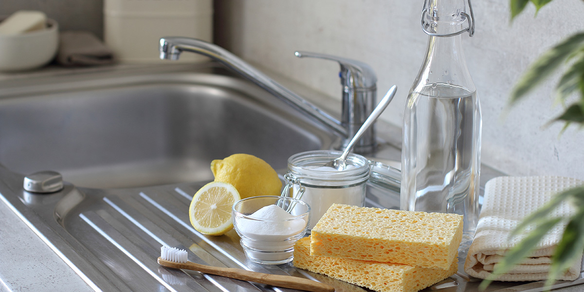 Image of all that you'll need to clean your sink: baking soda, sponges, lemonds, salt and more