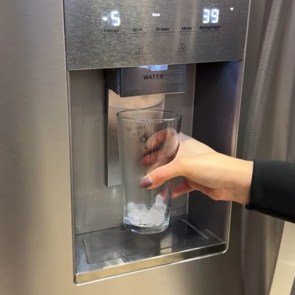 Person filling a glass with nugget ice.