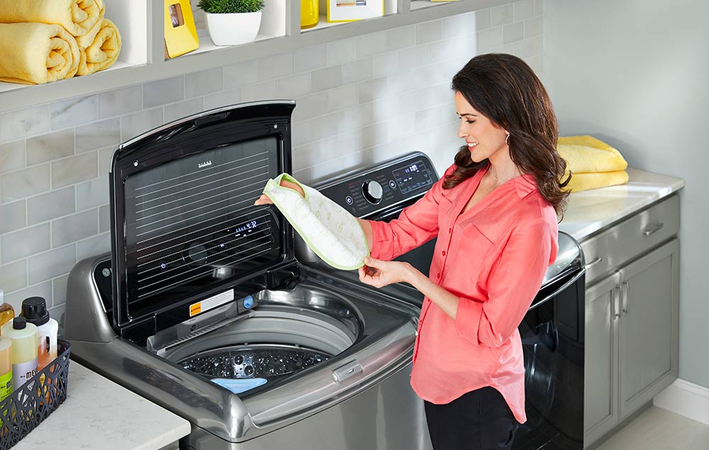 Person looking at baby bib over an open washer