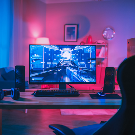 Gaming PC on a desk with pink and blue lighting