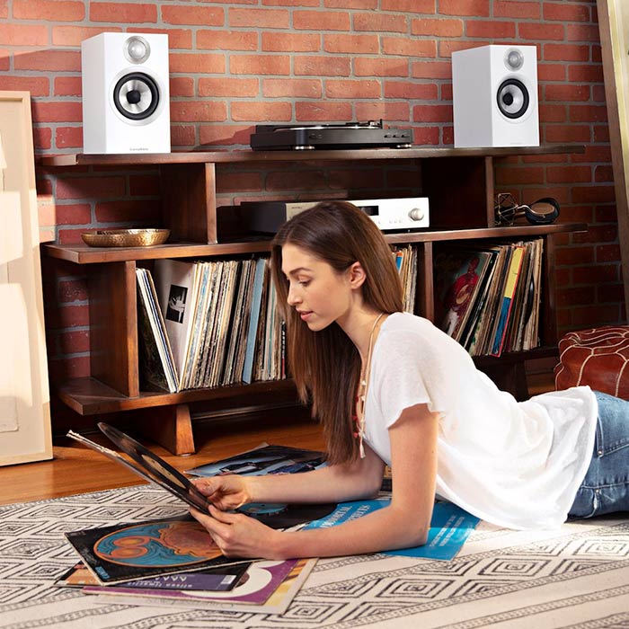 Person listening to records with Bowers and Wilkins speakers