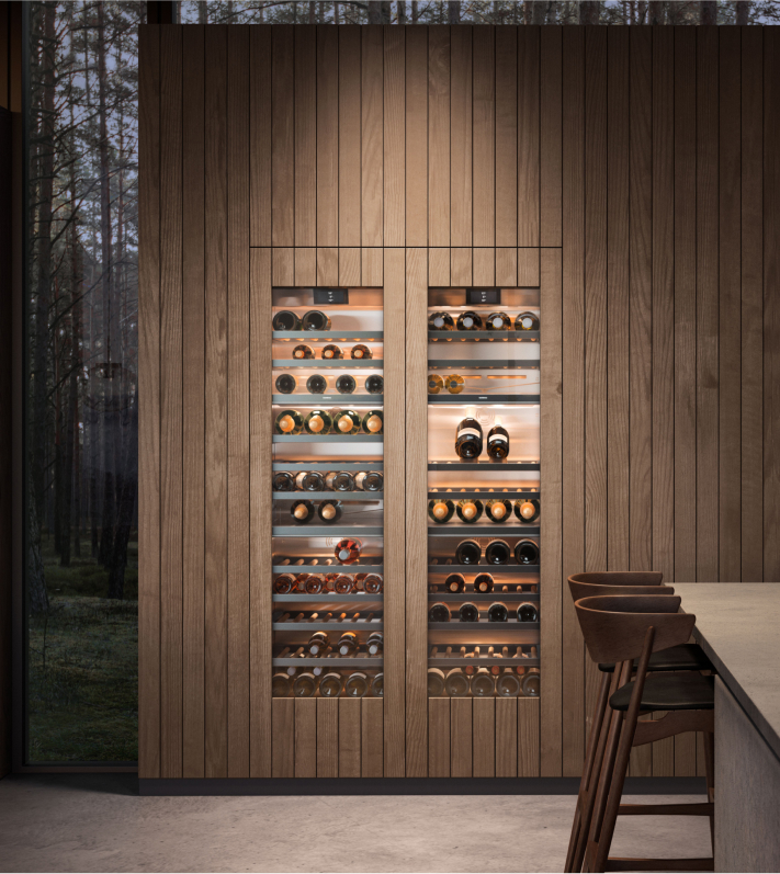 A stylish kitchen with wooden walls displaying a Gaggenau built-in wine refrigerator for optimal wine storage