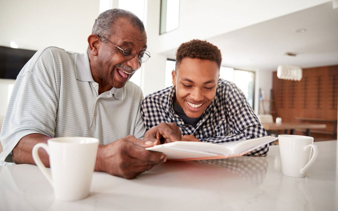 Man Looking at a Photo Album at Home with his Grandfather