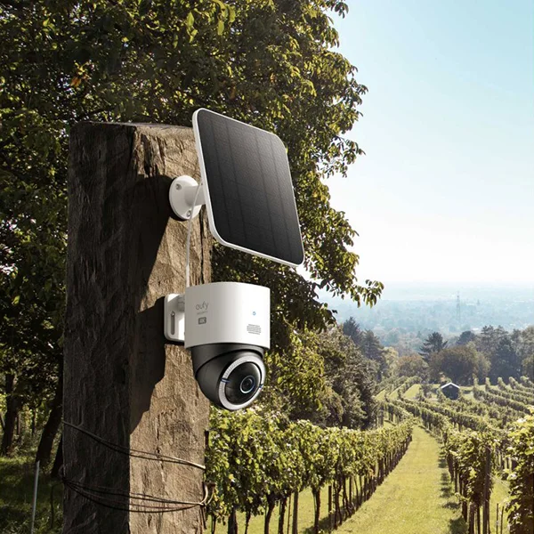 A eufy security camera mounted on a wooden post outside of a vineyard