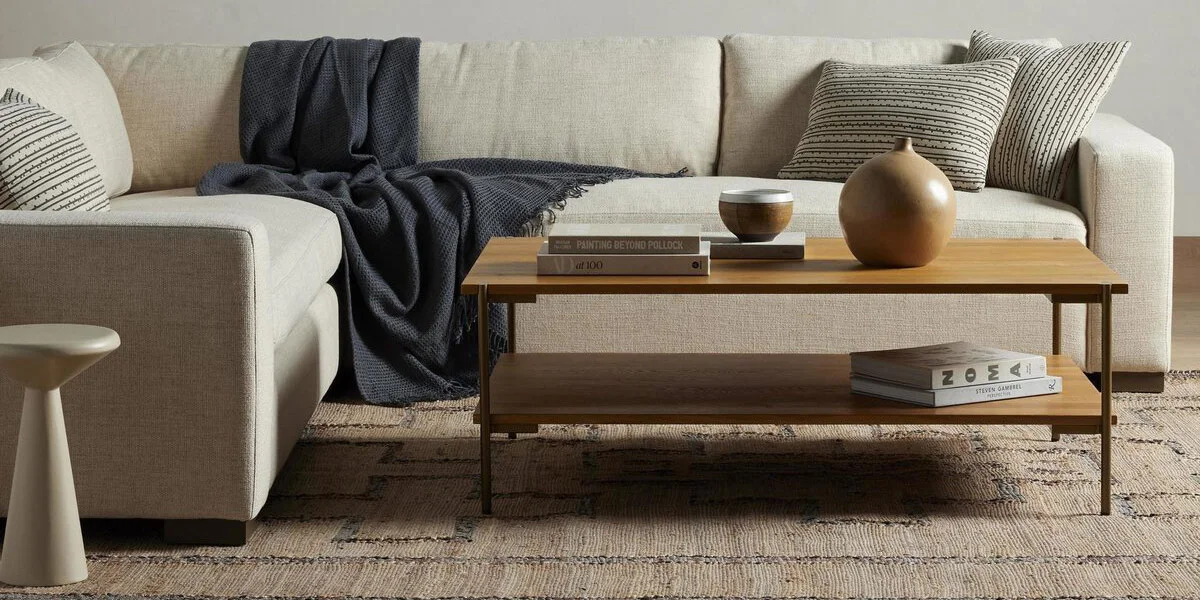 tan sectional sofa with navy throw blanket with a rectangular coffee table in front