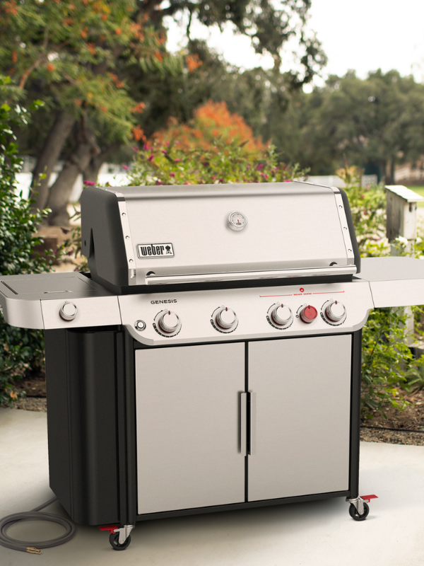Tight shot of a Weber Genesis Natural Gas Grill situated on a stoned corner of a patio