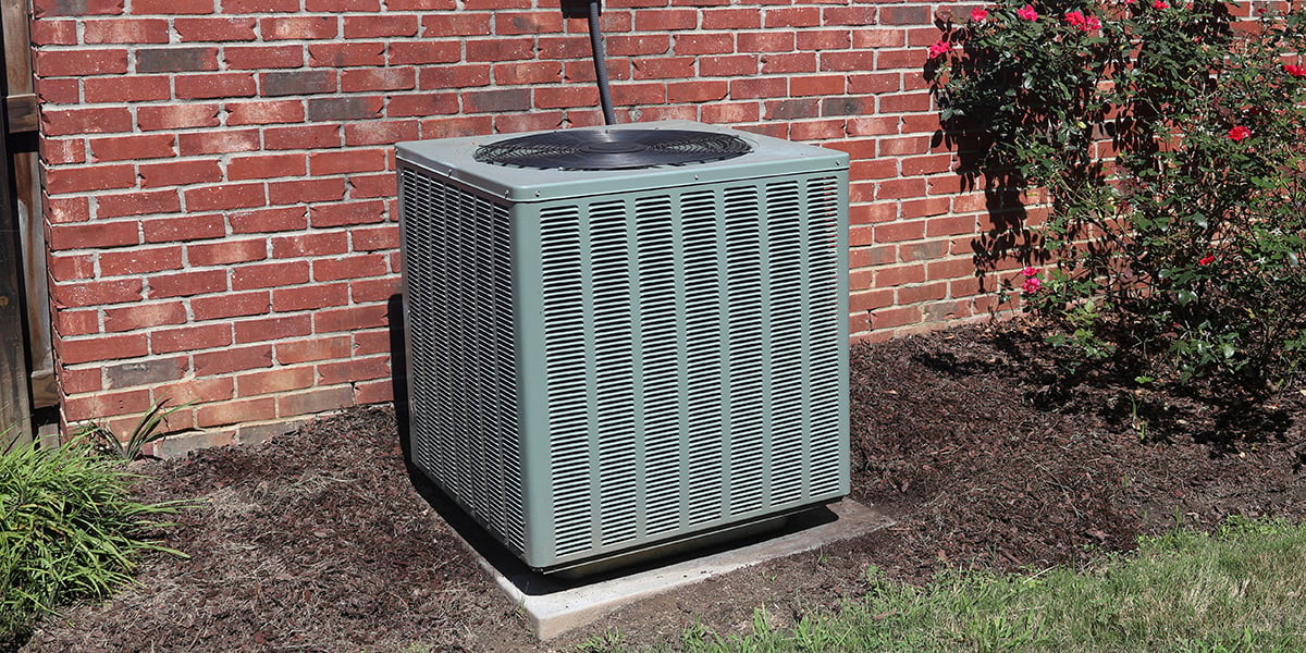 A central air conditioner outdoors with open space around it