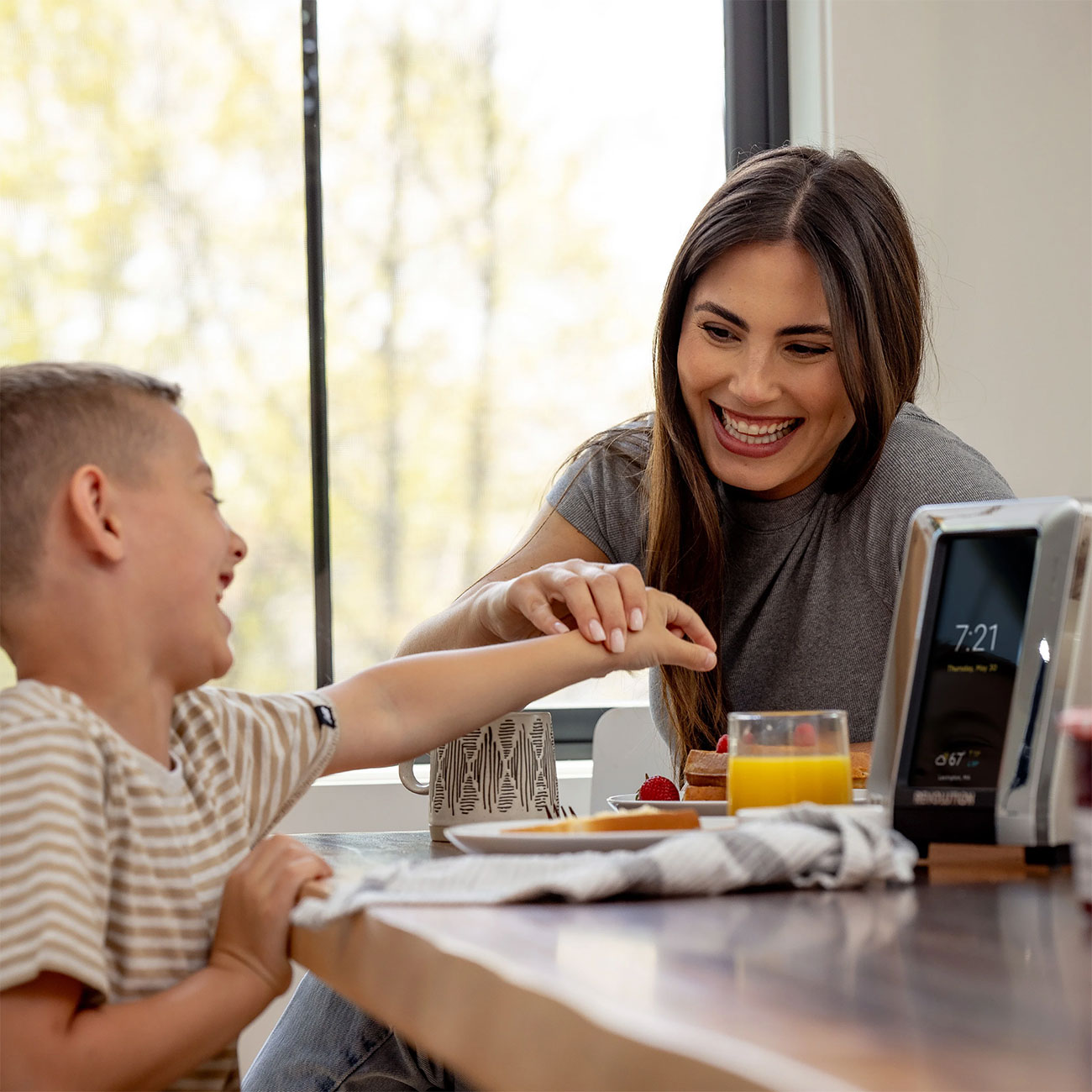 Family Eating Breakfast with Revolution Cooking Toaster on Table