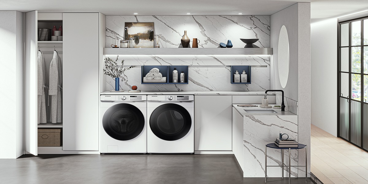 White front load washer and dryer side by side in a laundry room with white cabinets