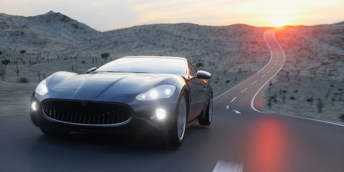 Black sports car with LED headlights driving on a road