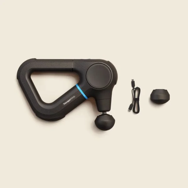 Flat lay of Theragun Prime massage gun and its attachments