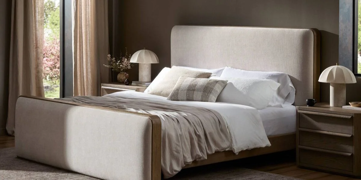 beige bed frame with headboard made with white and beige pillows and bedding