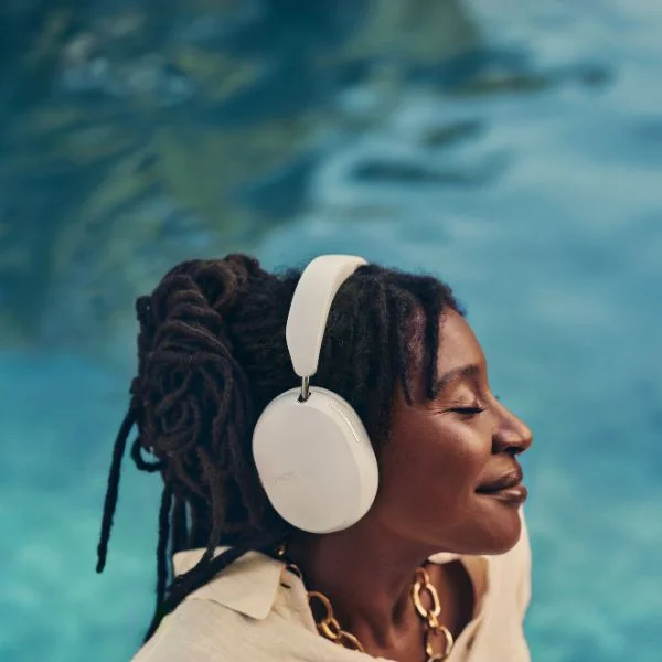 Woman wearing white Sonos Ace headphones.