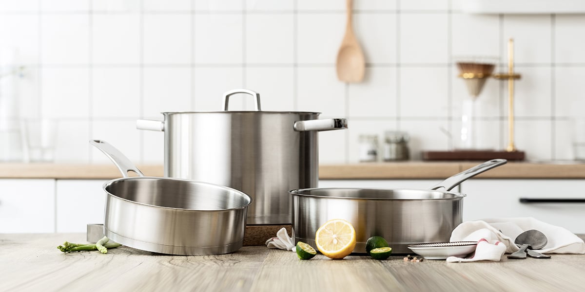 Stainless steel pots and pans on wooden counter