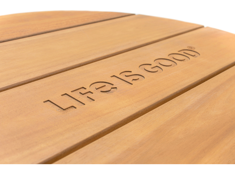 A close-up of a wooden stool with the words 'Life is Good' engraved on it.