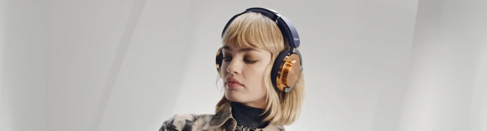 Dyson model looking down to the left with the On Trac Headphones on