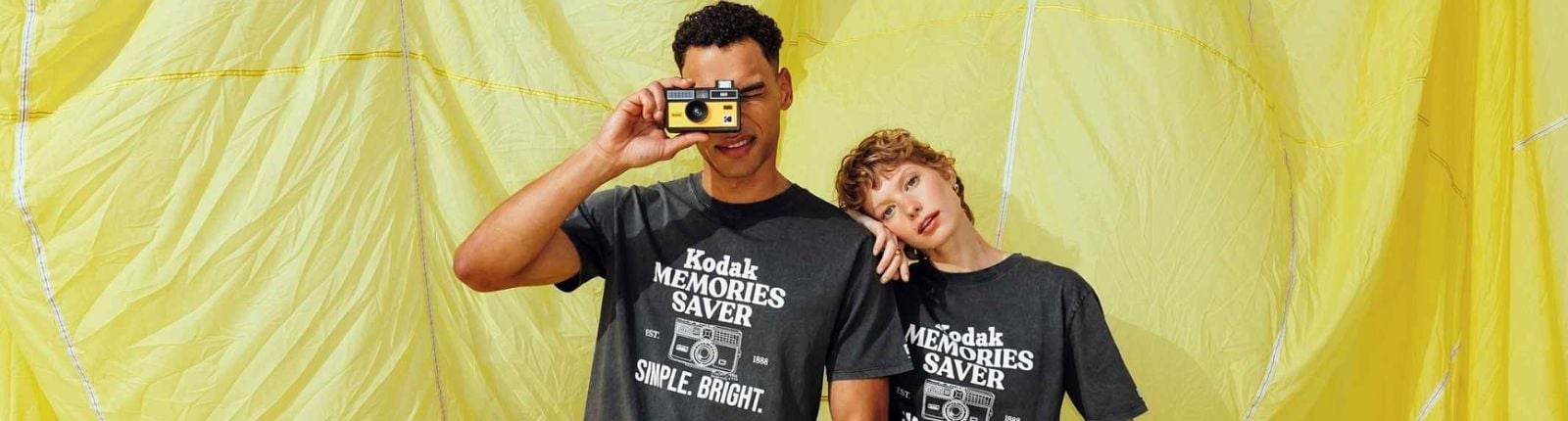 Two people with one taking a photo with a camera