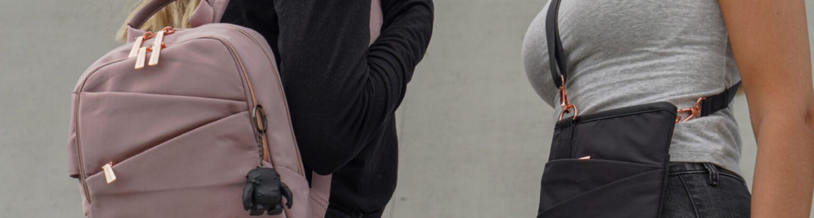 Two people one wearing a pink backpack, the other a black sling bag
