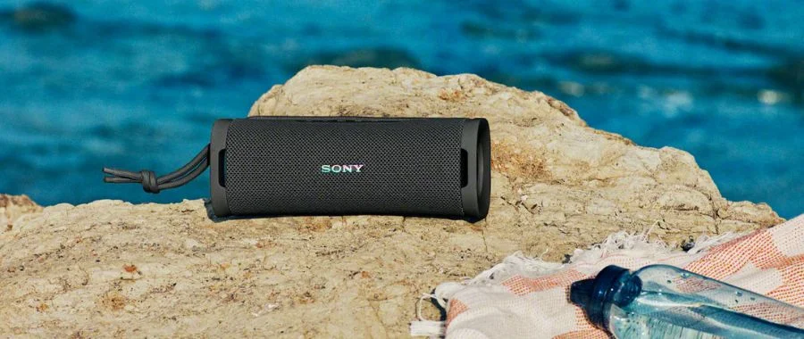 A Sony ULT Field 1 speaker sitting in the sand.