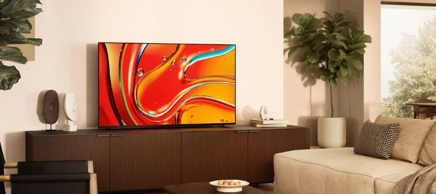 Sony Bravia television on a brown entertainment stand in a living room beside a bright window