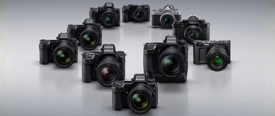 An array of Nikon digital cameras on a grey background.