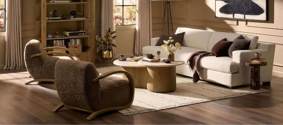 A living room filled with Four Hands furniture, with two shaggy accent chairs, a white sofa and dual coffee tables