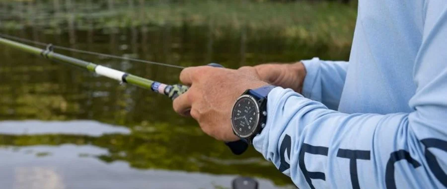 Garmin smartwatch on a fisherman's wrist as he casts the line