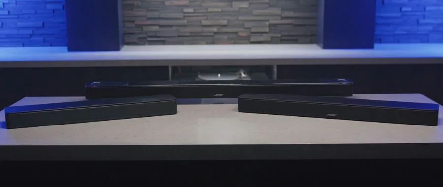 The Bose TV Speaker, Smart Soundbar and Smart Ultra Soundbar sitting on a table together.