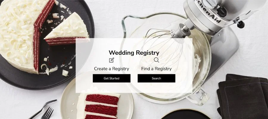 Aerial view of stainless steel KitchenAid mixer next to a red velvet cake and black napkins.