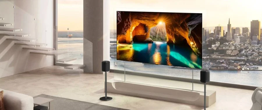 The LG wallpaper on a stand in a living room against a large clear window