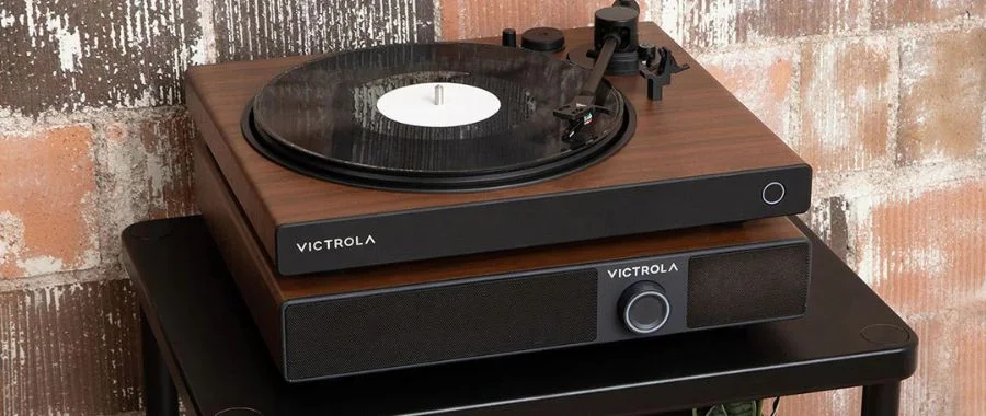 The Victrola Soundstage Soundbase speaker in Walnut with a matching turntable on top