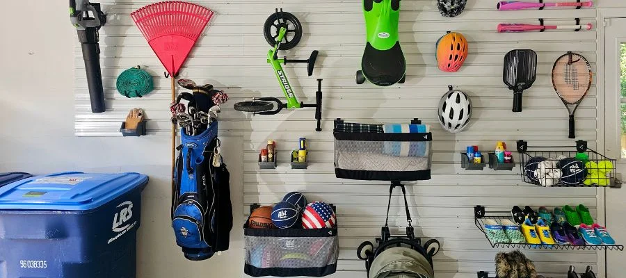 Wall components within a garage that are mounting outdoor tools and sports equipment.