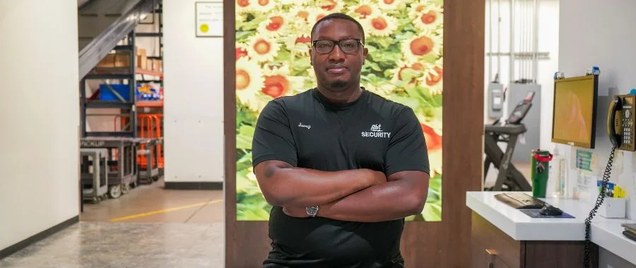 Semaj Gladden at Abt's Merchandise Pickup counter in fronts of a screen of sunflowers